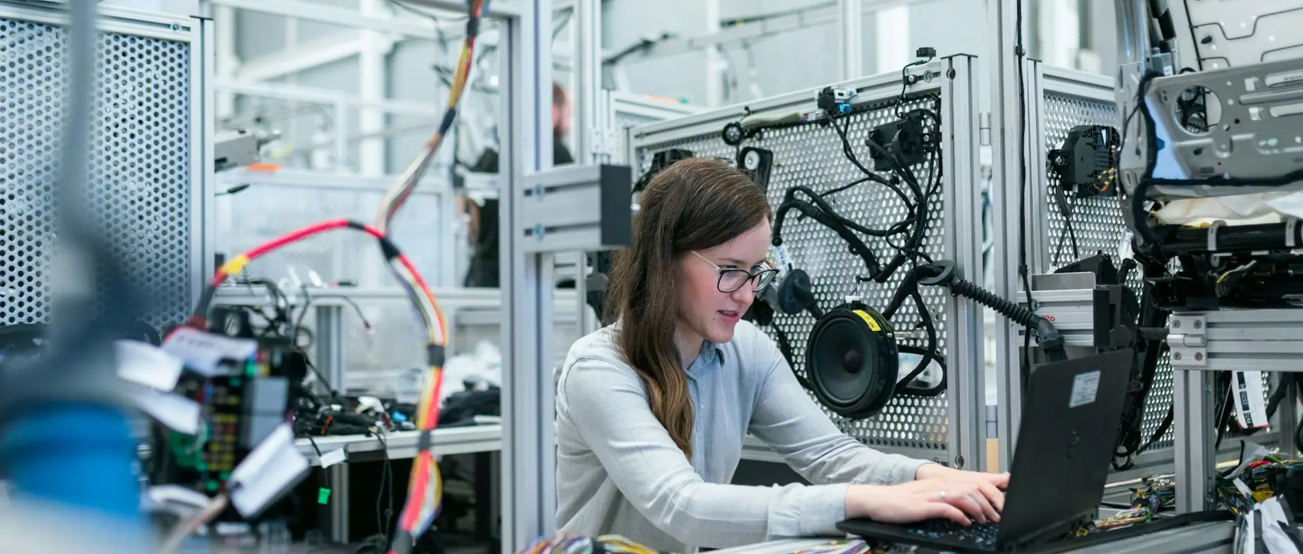 An engineer at a laptop on an electronics production line, the kind of manufacturer Sourceforce verifies